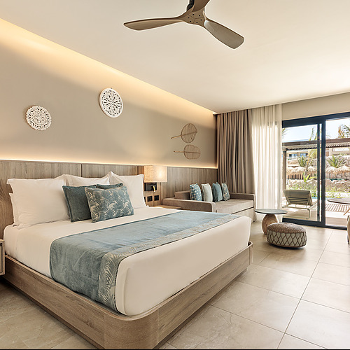 Habitación de lujo con cama king, sofá y balcón con vista a la piscina. Serenade Corpo