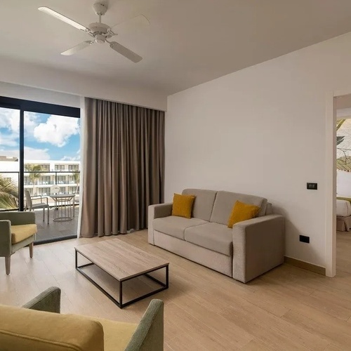 una sala de estar con sofá y ventilador de techo