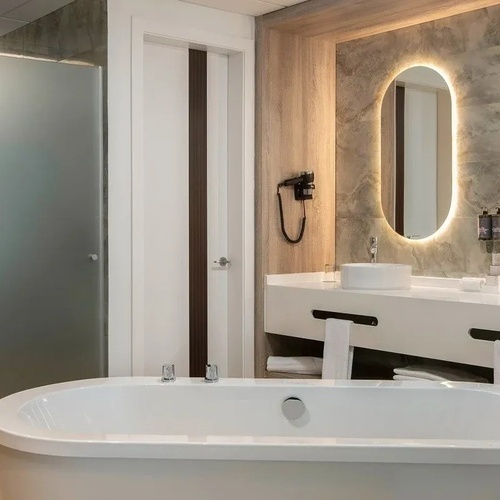 un baño con dos lavabos y una bañera