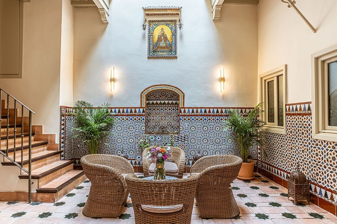 una piscina rodeada de palmeras y una casa