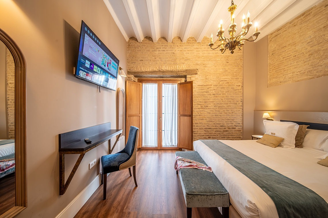 Habitación de hotel con TV, escritorio y cama cómoda, diseño rústico y elegante. SHC: Halo Boutique Hotel