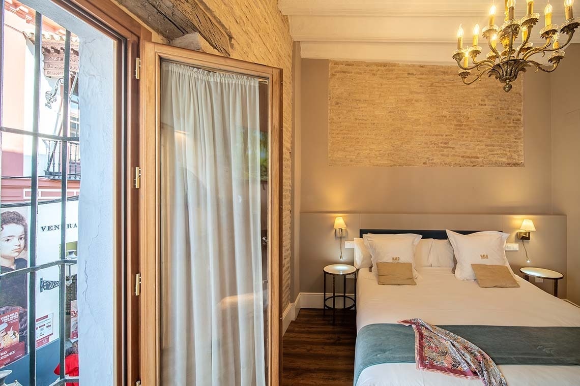 Habitación de hotel doble con ventana y vistas a la calle, estilo rústico chic, cama cómoda.