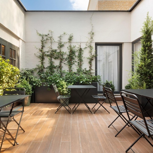 a courtyard with tables and chairs and plants