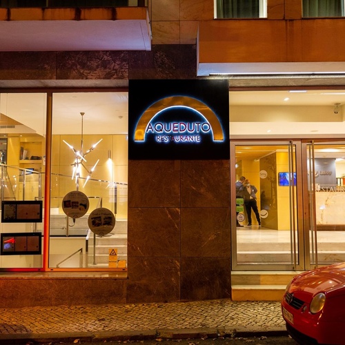 a building with a sign that says aqueduto it 's granite