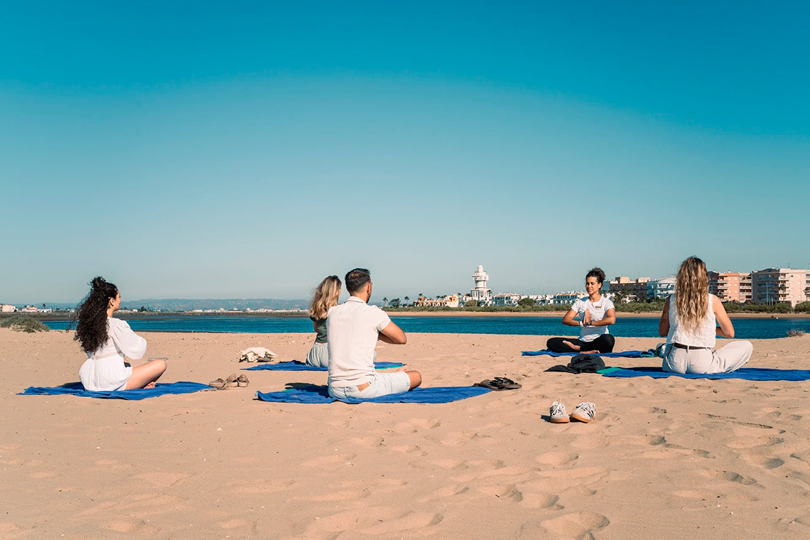 Yoga Smy: Corporativa session on a sandy beach with ocean and buildings in the background