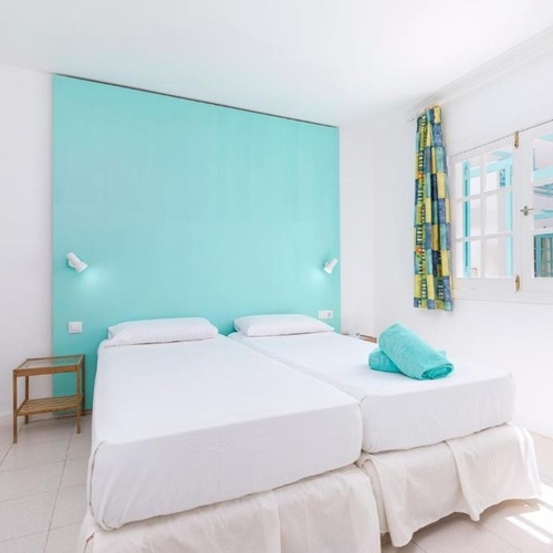 ein Schlafzimmer mit zwei Betten und einer blauen Wand