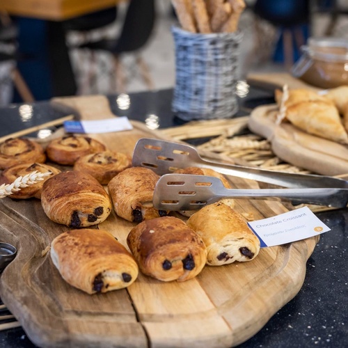 une planche à découper en bois avec des pains au chocolat sur elle