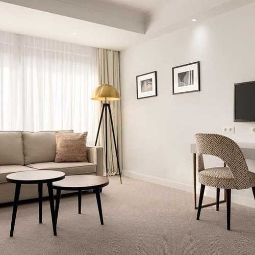 a living room with a couch two tables and a flat screen tv