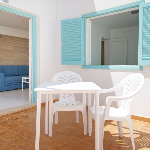 ein Tisch und Stühle auf einem Balkon mit blauen Fensterläden