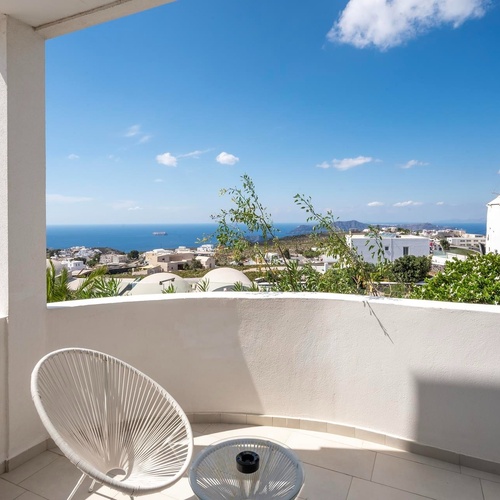 ein weißer Stuhl sitzt auf einem Balkon mit Blick auf den Ozean