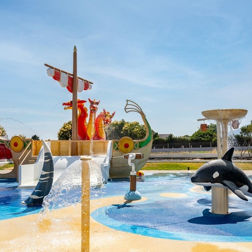 a water park with a ship and a whale