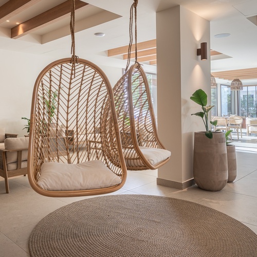 Cadeiras suspensas de vime e sofás, ideais para um ambiente relaxante Smy: Corporativa.