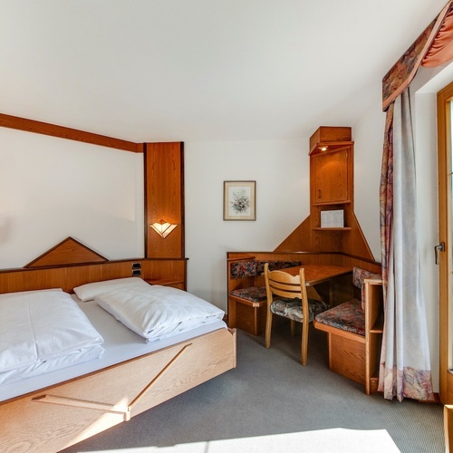 a bedroom with a bed and a desk with a picture on the wall