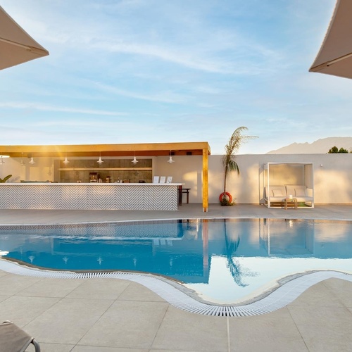 a large swimming pool with a bar in the background