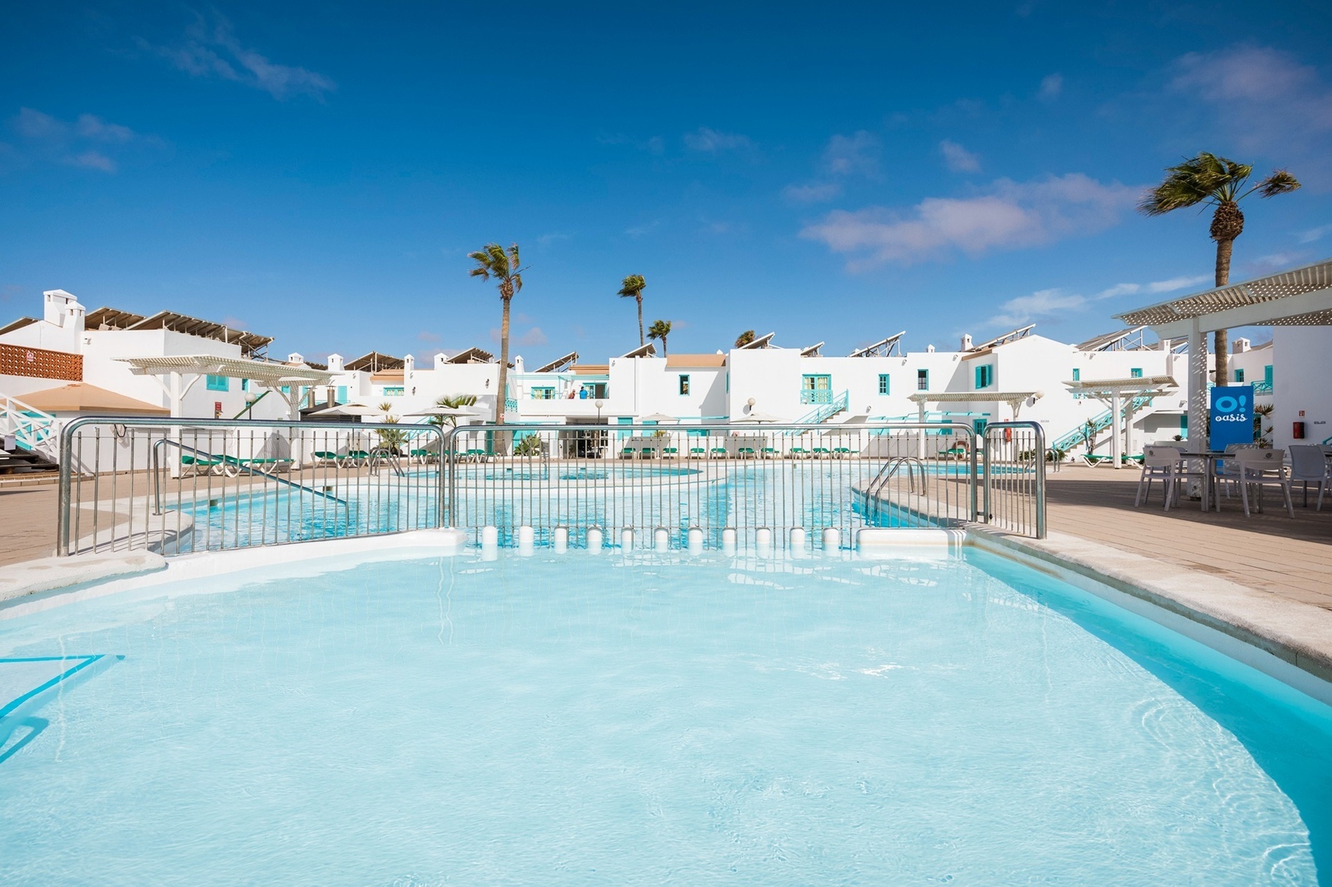 ein großer Swimmingpool mit weißen Gebäuden im Hintergrund