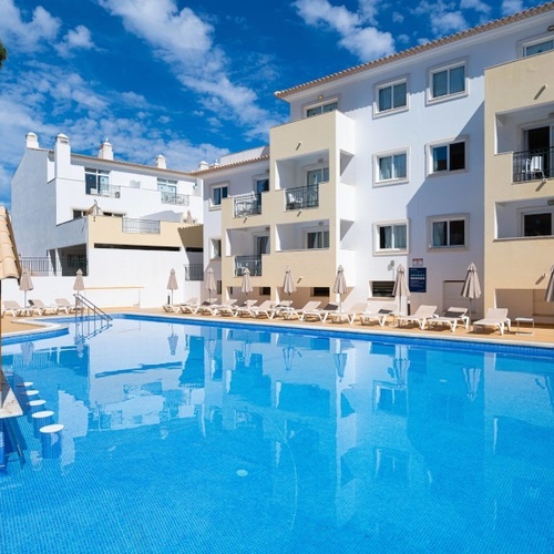 a large swimming pool is surrounded by chairs and umbrellas