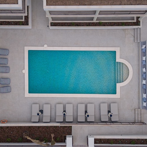 Piscina de hotel moderna com espreguiçadeiras e área de lounge Smy: Corporativa.