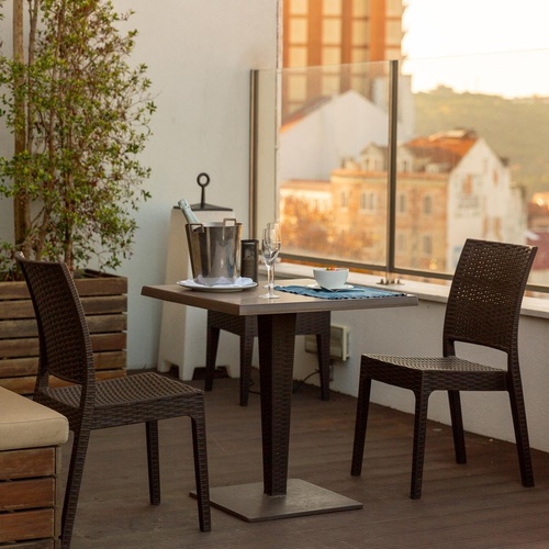 a table and chairs on a balcony with a view of a city