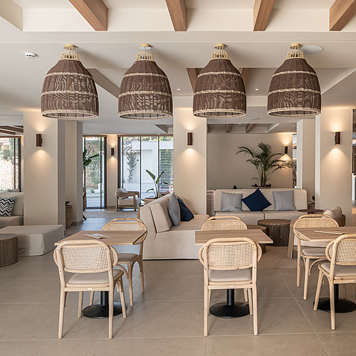 Stylish Smy: Corporativa hotel lobby with central olive tree and circular seating.