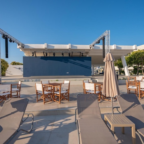 a stage with tables and chairs and umbrellas in front of it