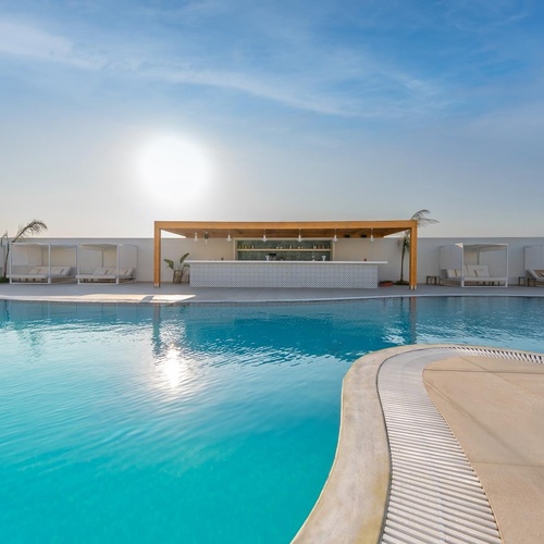 a large swimming pool with a bar in the middle