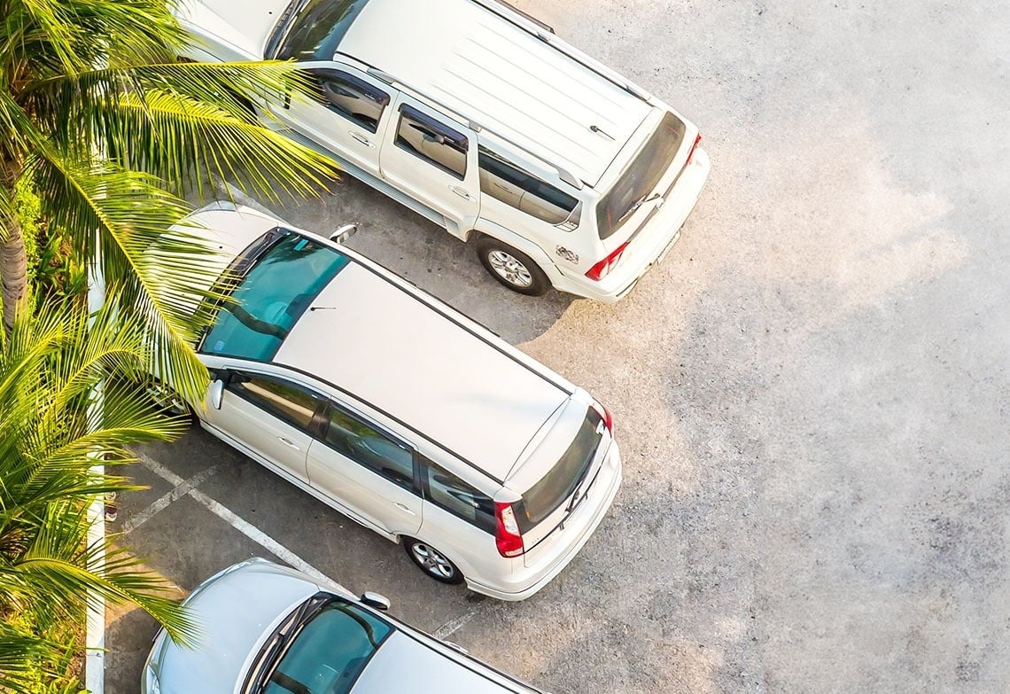tre veicoli bianchi sono parcheggiati uno accanto all'altro in un parcheggio