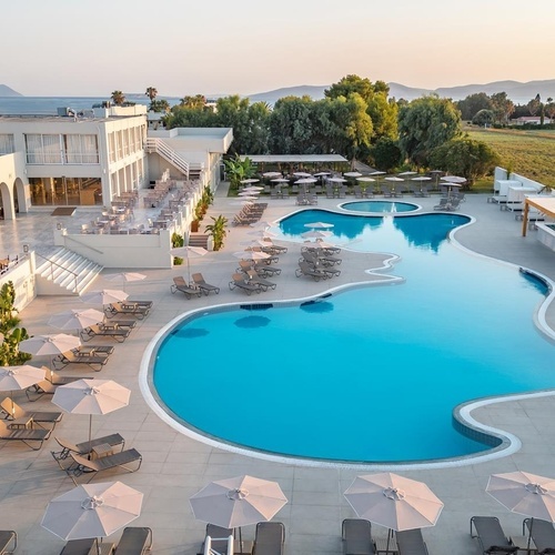 a large swimming pool surrounded by chairs and umbrellas