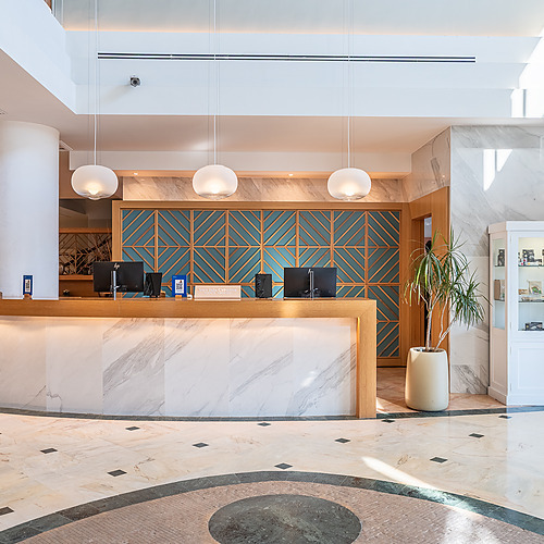 Smy: Corporativa Hotelrezeption, moderner Lobby mit Sofas und Hängeleuchte.