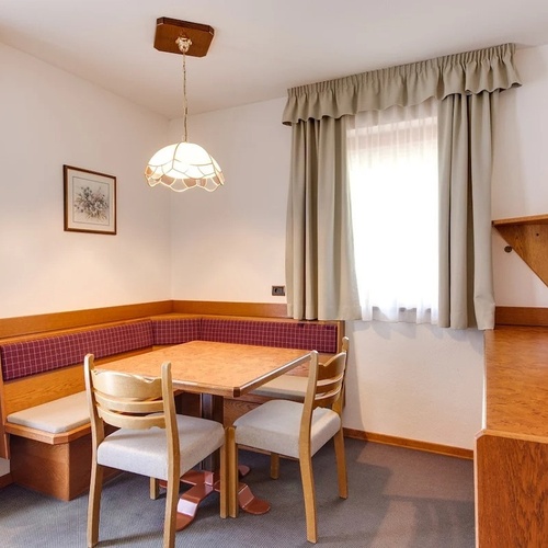 a small room with a table and chairs and a flat screen tv