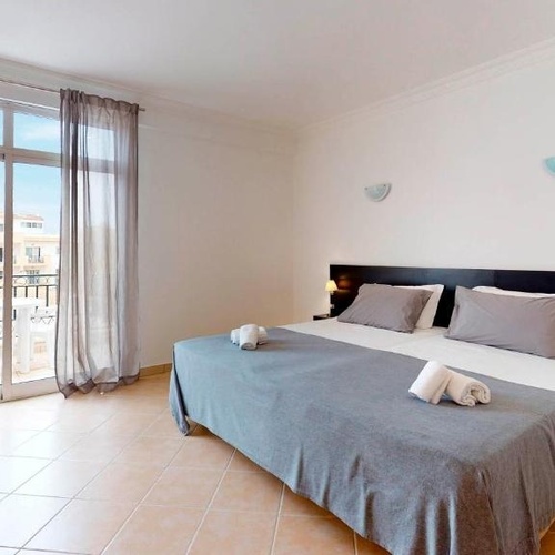 a hotel room with a large bed and a balcony