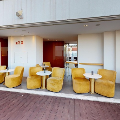 a restaurant with yellow chairs and white tables