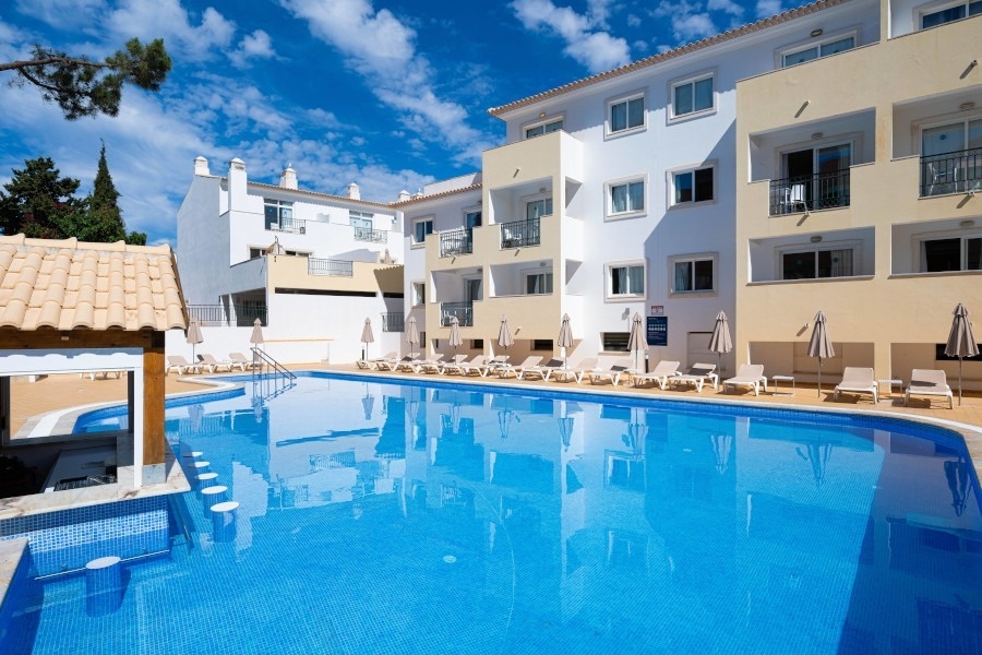 a patio with tables and chairs surrounded by potted plants