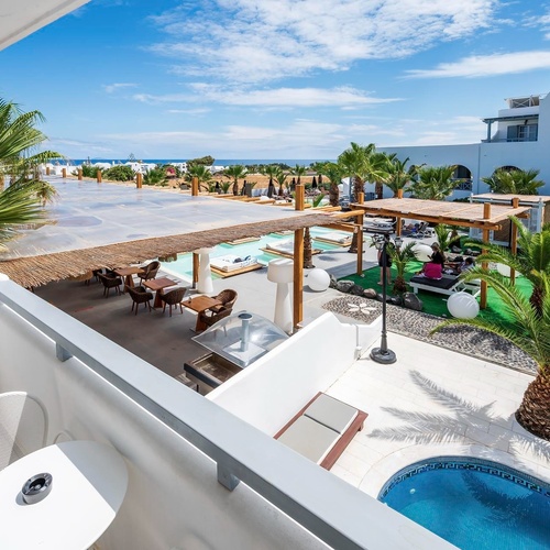 un balcon avec une table et des chaises à côté d' une piscine