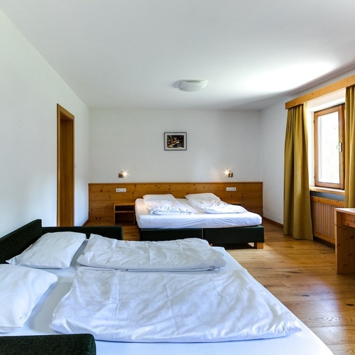 a hotel room with two beds and a flat screen tv