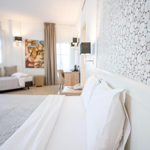 ein Hotelzimmer mit einem Bett und zwei Einzelbetten