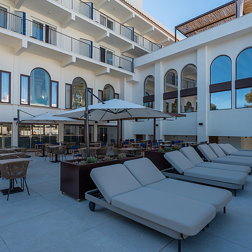 Stylish Smy: Corporativa hotel lobby with central olive tree and circular seating.