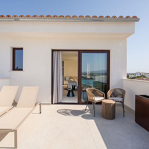 Smy: Corporativa bedroom with king bed, bathroom, and balcony. Natural design.