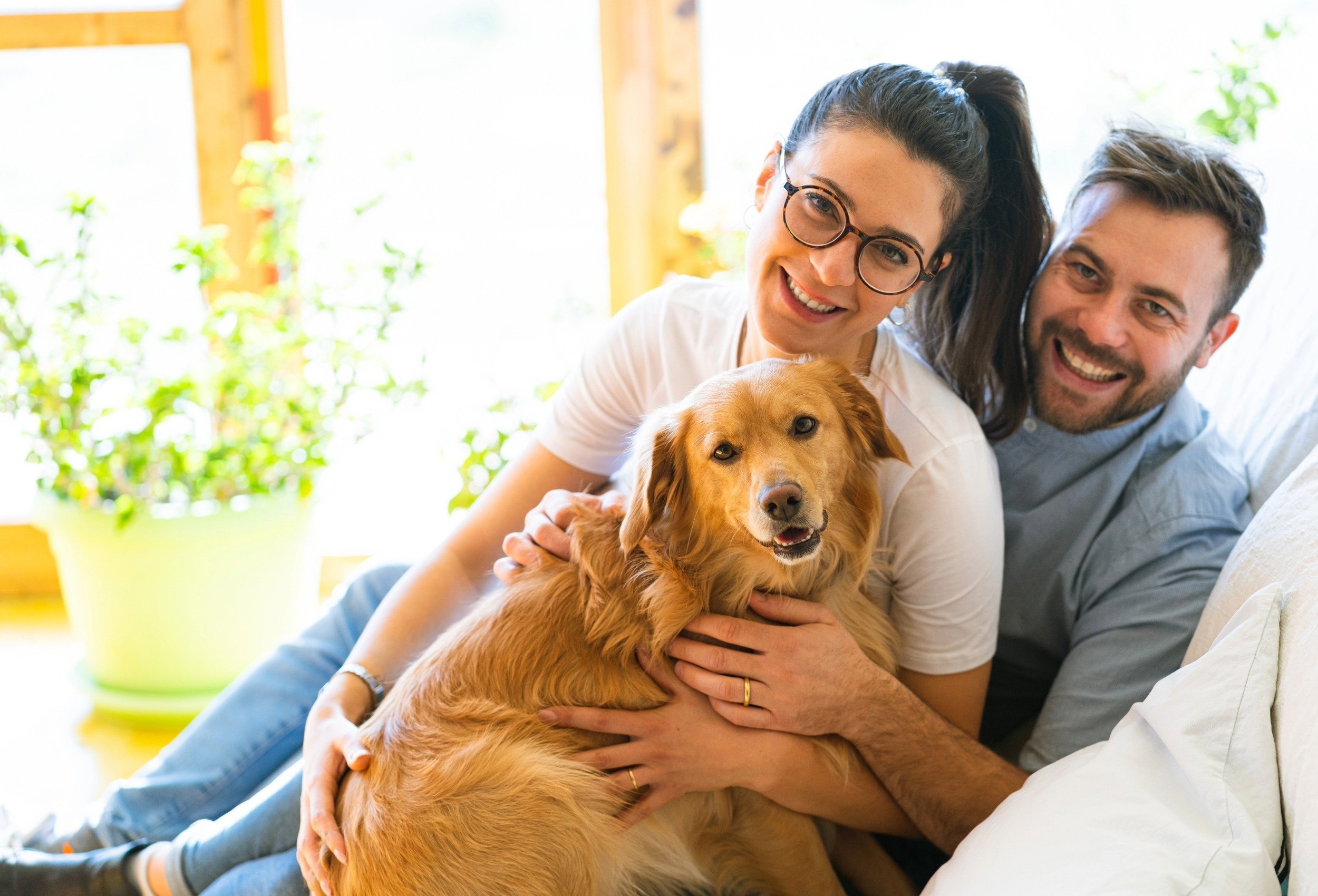 un uomo e una donna sono seduti su un divano con un cane