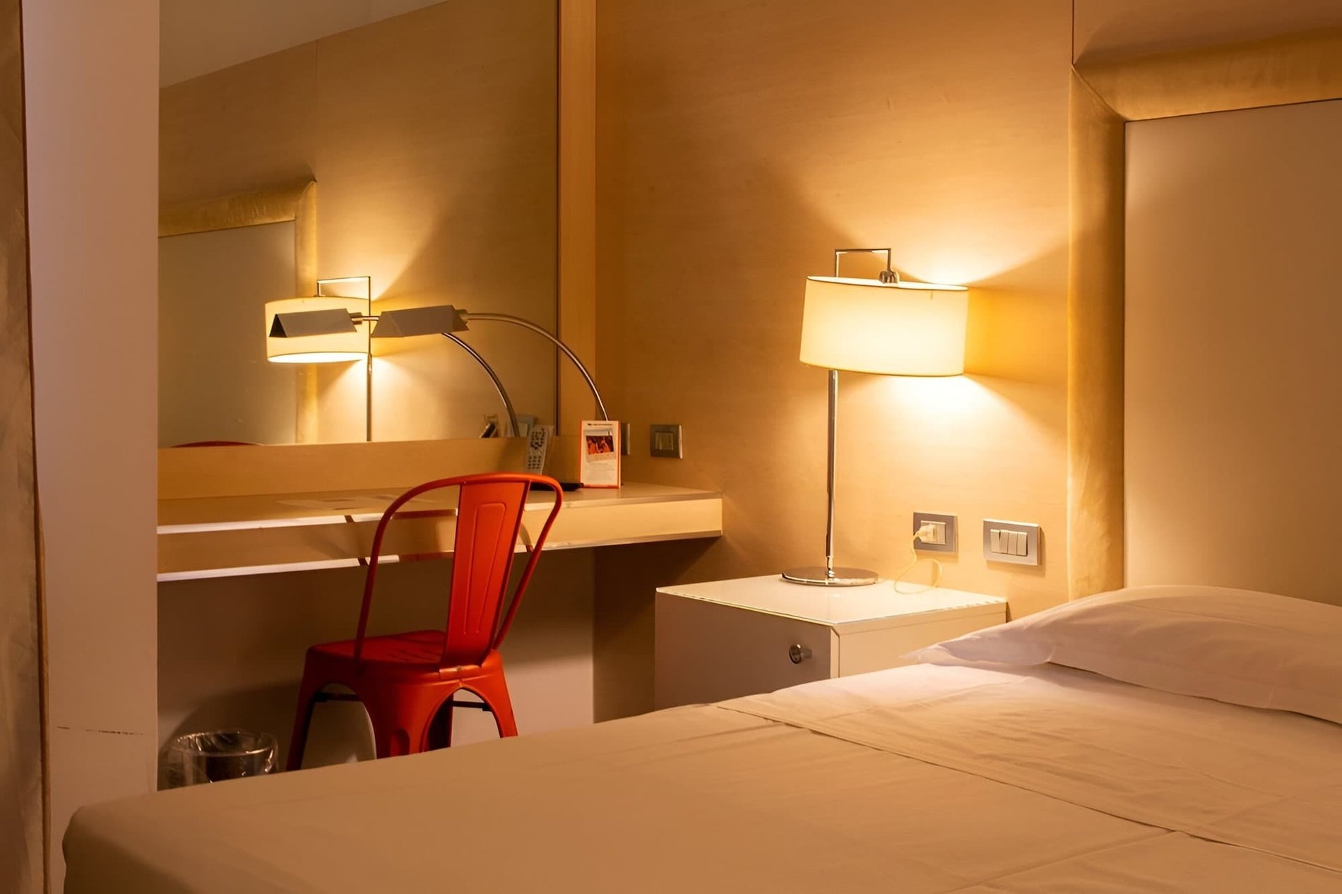 una camera d' albergo con letto , scrivania e balcone