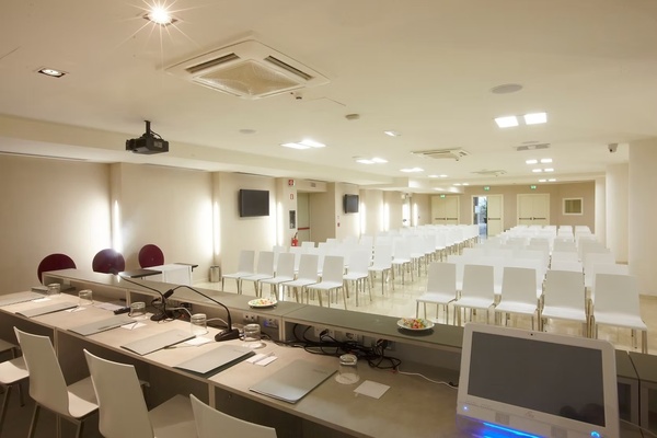 una sala de conferencias llena de mesas y sillas