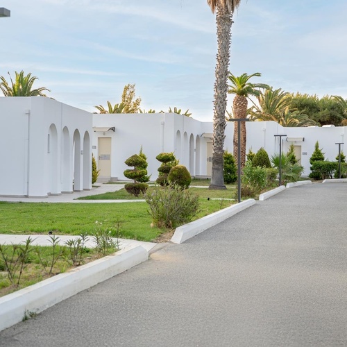 a row of white buildings with a walkway leading to them
