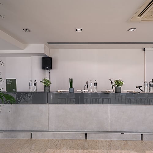 Salle de conférence avec podium, micros et plantes. Idéal pour Smy: Corporativa.