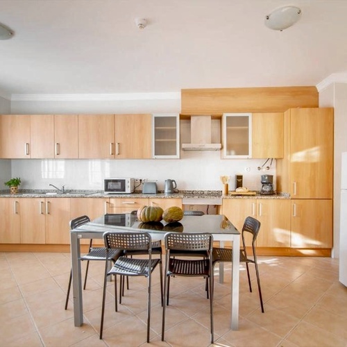 a kitchen with a table and chairs and a refrigerator