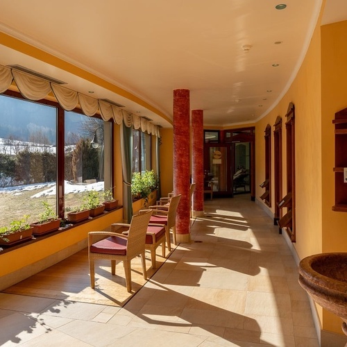 a long hallway with chairs and a stone sink