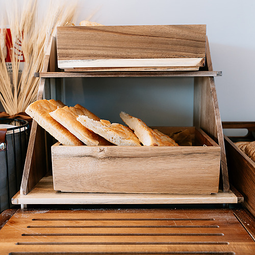 Tranches de pain dans une boîte en bois sur un présentoir deSmy: Corporativa hôtel.