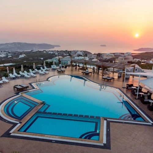 ein großer Pool mit einem Sonnenuntergang im Hintergrund