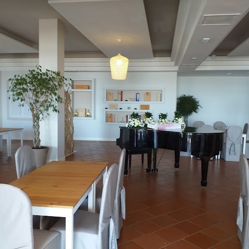 ein großer Raum mit Tischen und Stühlen und einem Klavier