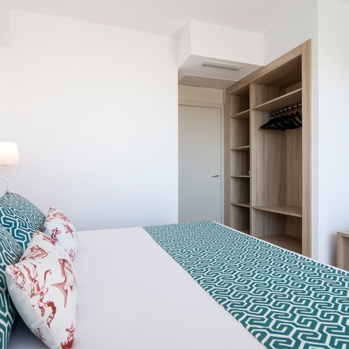 um quarto com uma cama e um guarda-roupa