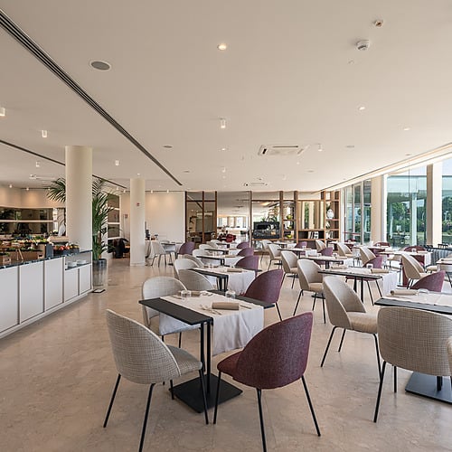 Salle de restaurant lumineuse avec tables dressées et buffets, idéale pour Smy: Corporativa.