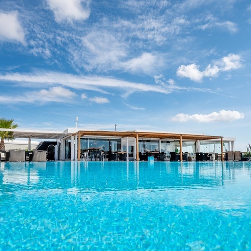 a large swimming pool with a restaurant in the background